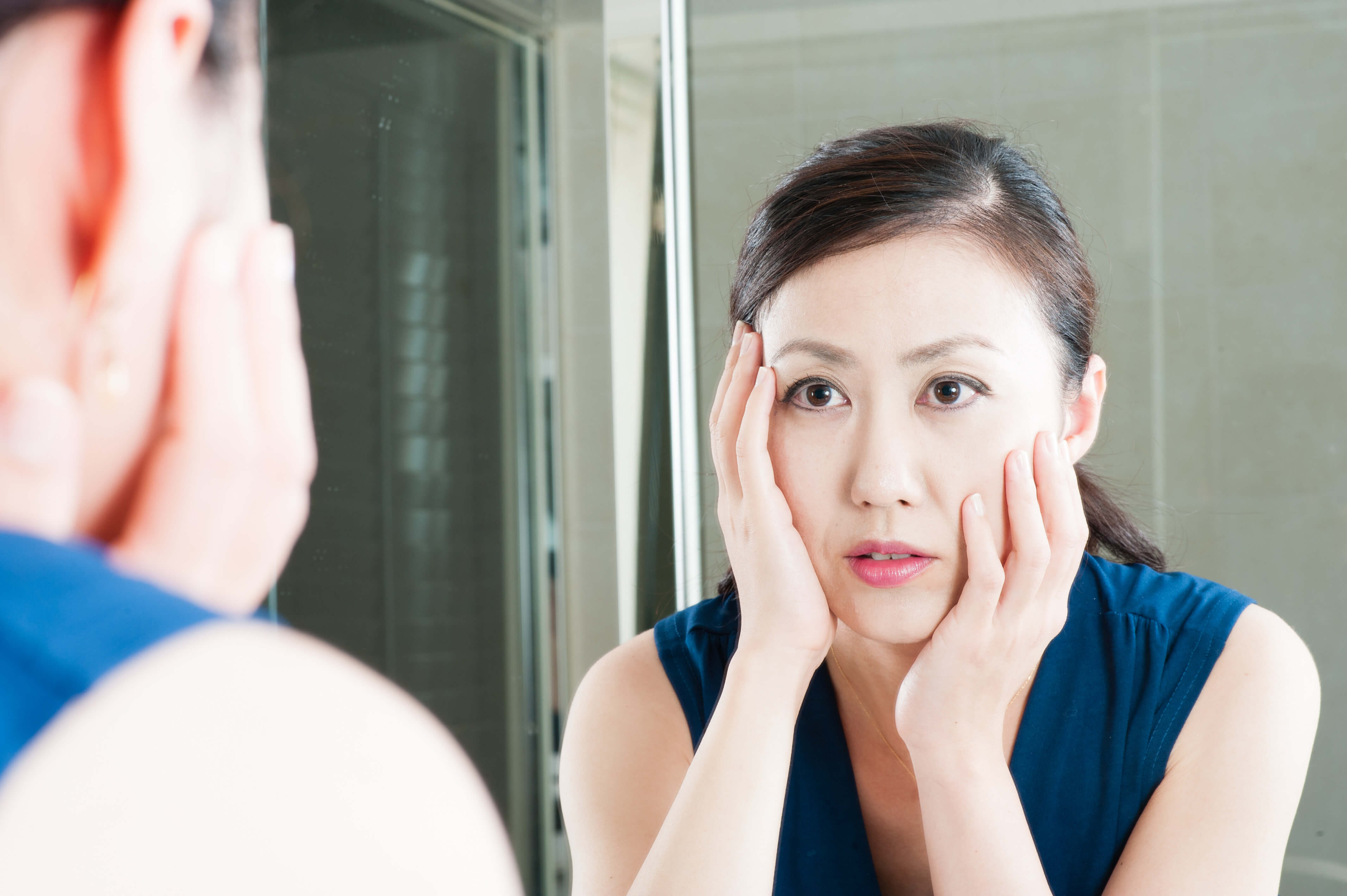 鏡を見る女性の写真